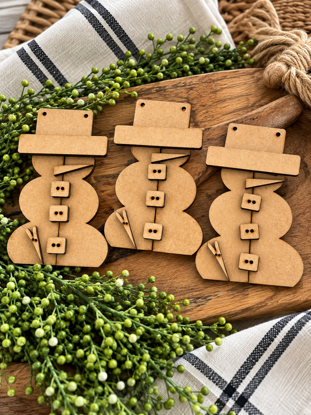 Unfinished MDF three-piece scrap wood snowman ornament set on rustic board