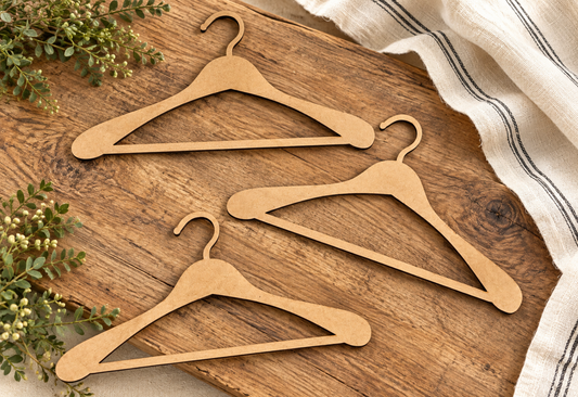 Three unfinished wooden hangers on a rustic tabletop