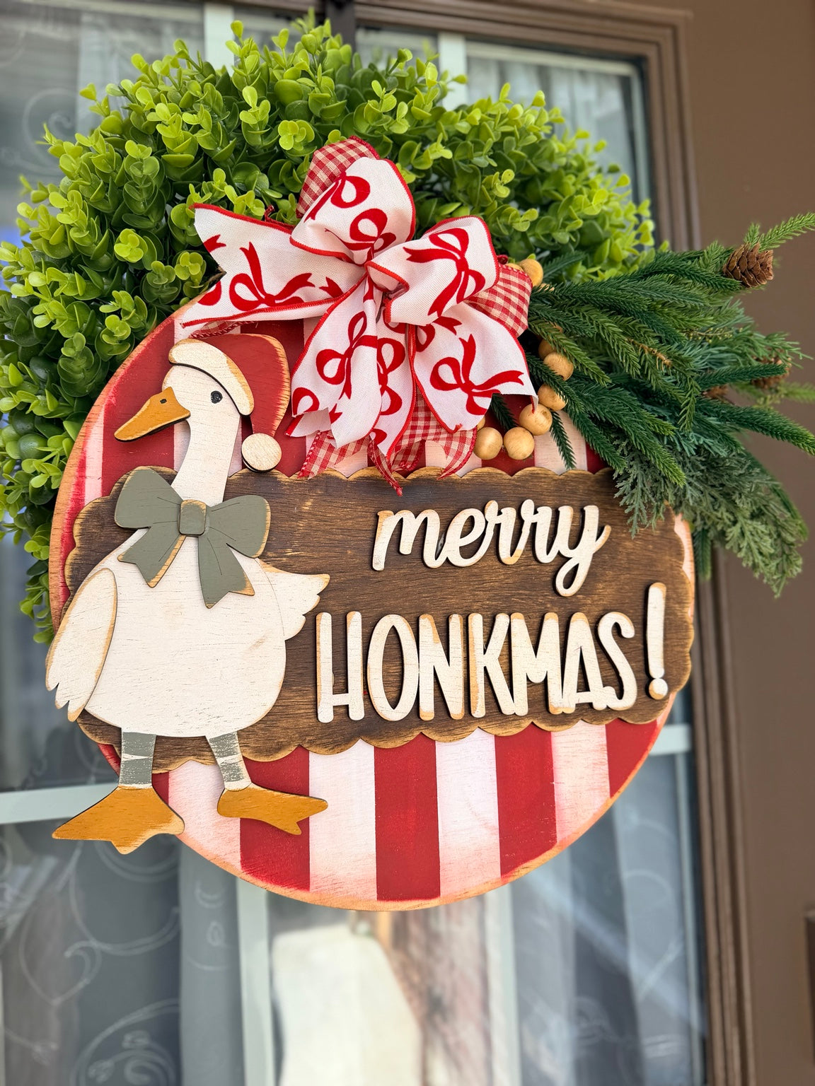 Painted example of Merry Honkmas goose DIY wood kit with red and cream stripes and green bow